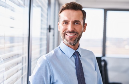 older man in tie smiling