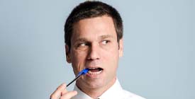 man with dental implants in Roselle Park chewing on a pen