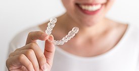Closeup of patient holding Invisalign clear aligner
