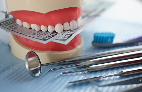 Model of teeth on dental instrument table biting bills