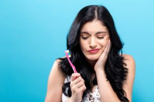 woman in pain with toothbrush