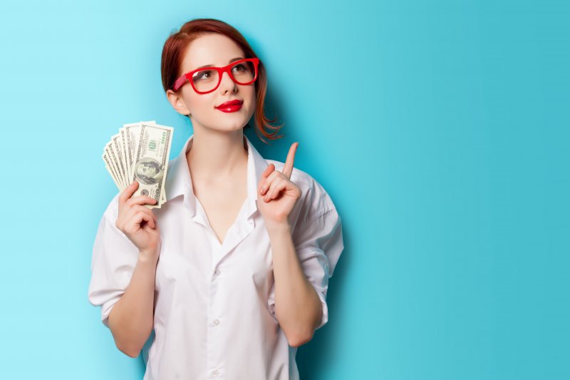 woman thinking while holding money